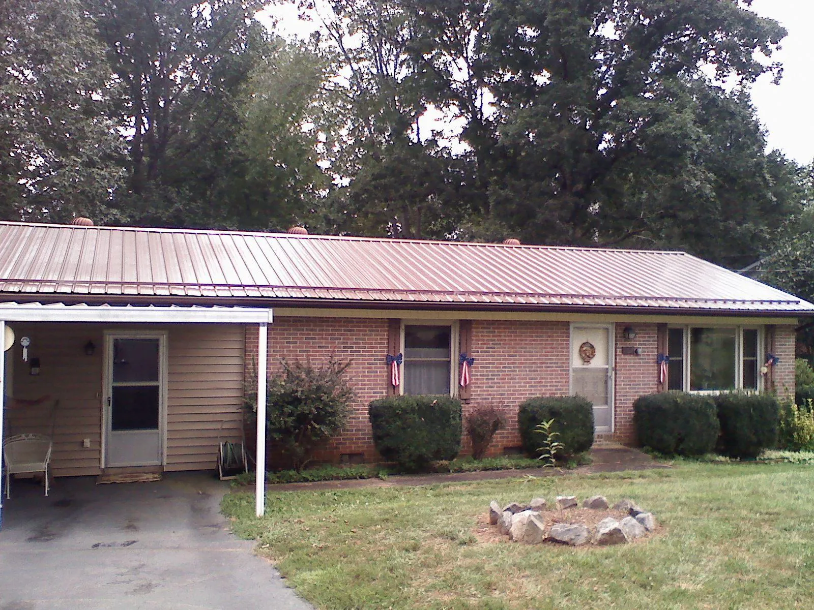 Bronze metal roof and carport on a brick ranch home — Roof Repair work by our crew in Lonsdale